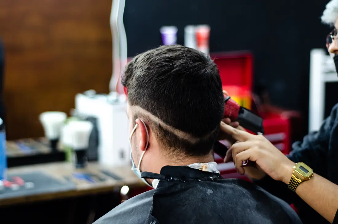 Barbero de Barber Shop trabajando un corte a un cliente en el local